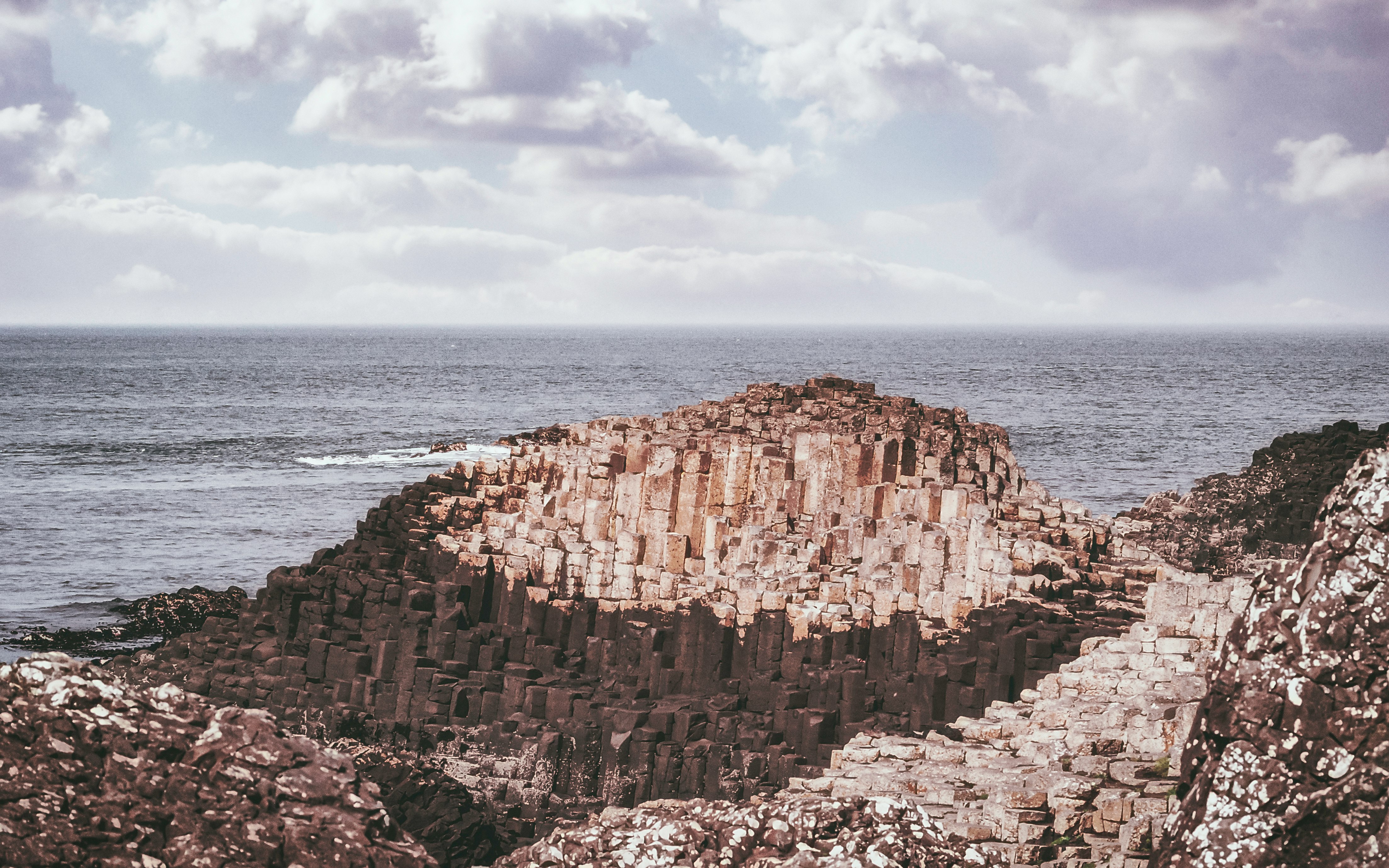 brown rock formation near body of water during daytime